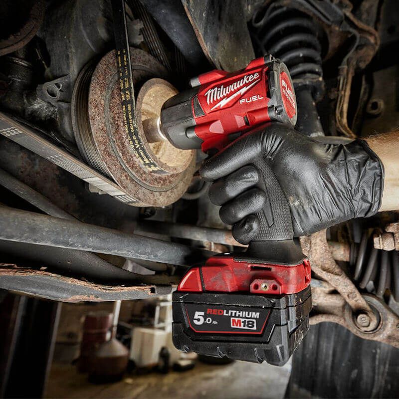 Action shot of the Milwaukee M18 FUEL Cordless 4-Mode ½″ Impact Wrench in use, demonstrating its 881 Nm nut-busting torque and 4-Mode DRIVE CONTROL™ for powerful and precise performance in demanding tasks.